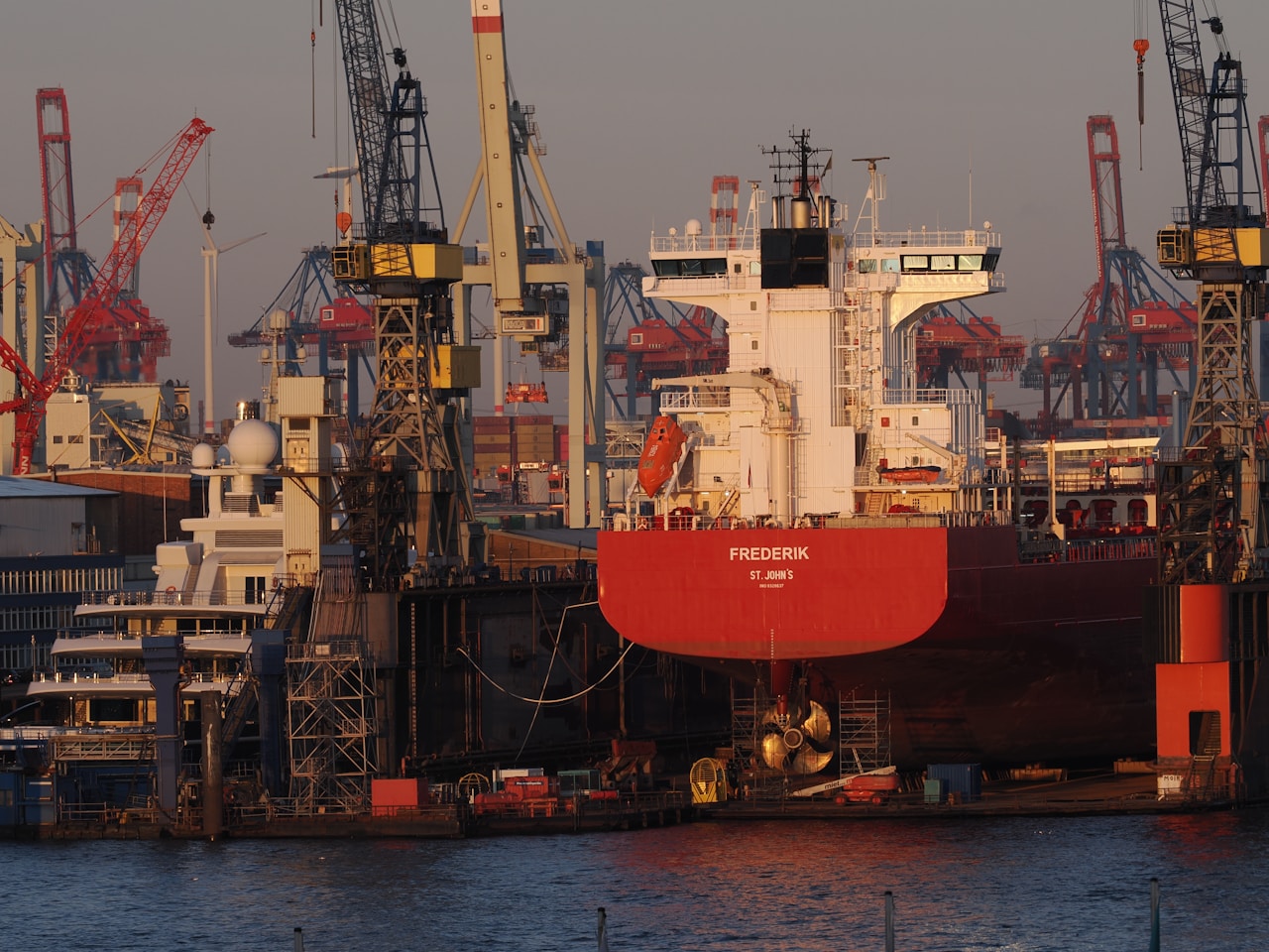 Large commercial cargo ship in dry dock for hull maintenance and recoating