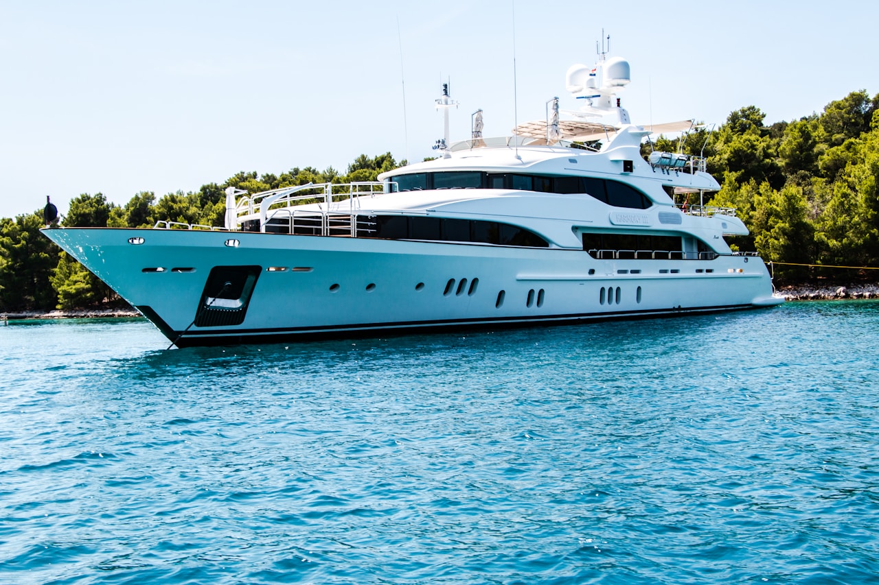 White leisure yacht moored on calm water for hull and topside refinishing